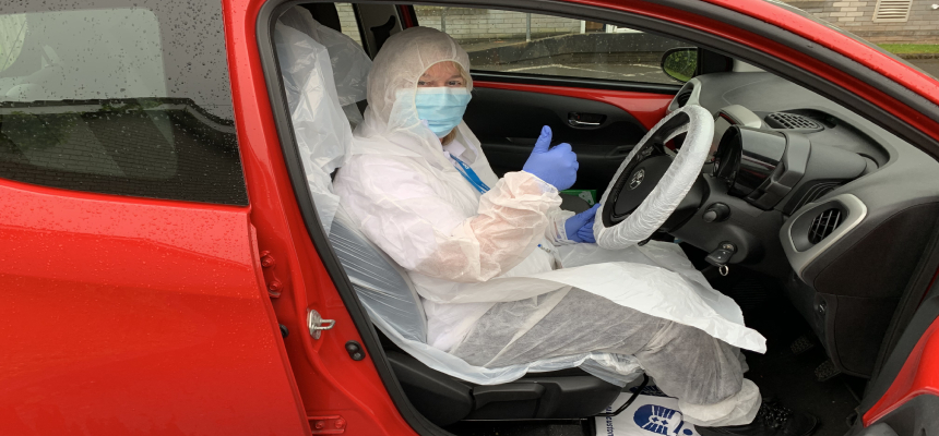 Photo: Rapid Response Support Worker Juliet Wilson dressed in PPE in her car with its own PPE