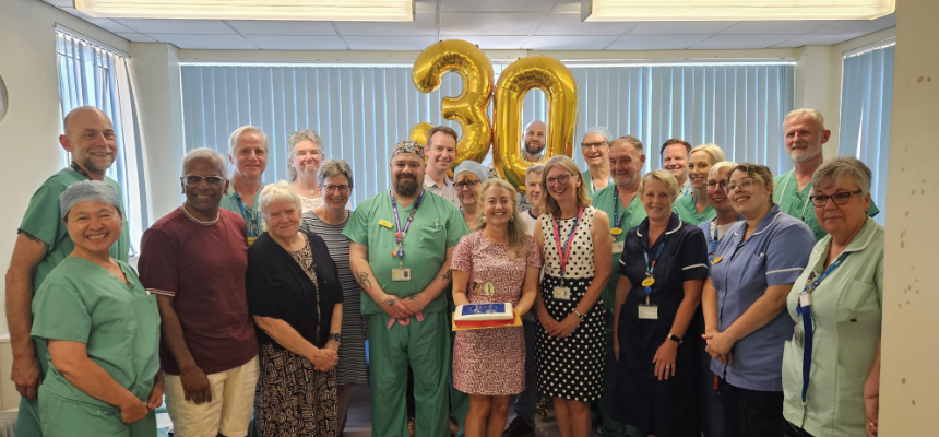 Group of people smiling and holding a cake